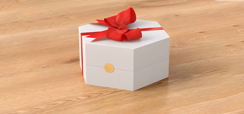 White hexagonal gift box with a red ribbon and bow placed on a wooden floor.